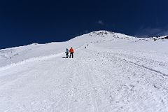 
Zig Zagging To Climb Steep Trail To Pastukhov Rocks With Mount Elbrus West And East Summits Above
